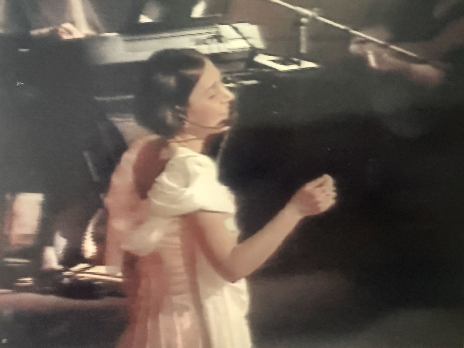 Angela singing on stage during her years as a professional actress and vocalist
