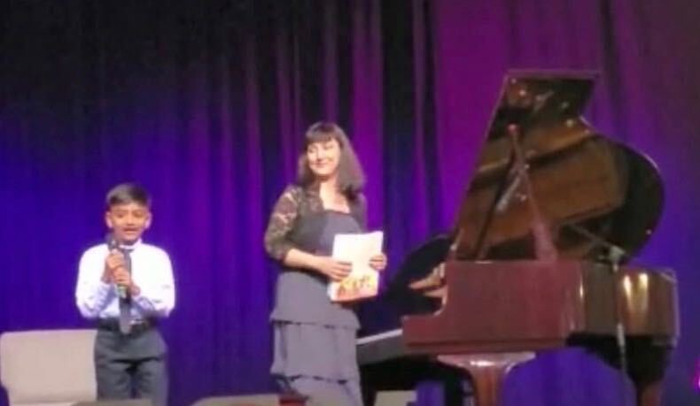 Student singing with Angela at the piano during a recital